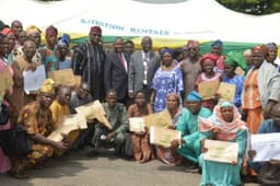 Representative of the Ogun State Governor and Head of Service, Mr. Abayomi Sobande (middle), Chief of Staff to the Governor, Chief Tolu Odebiyi (4th left), Commissioner for Urban and Physical Planning, Mrs. Ronke Sokefun (5th right) and Commissioner for Information and Strategy, Chief Adedayo Adeneye (4th right) with some of the beneficiaries who were presented with their Certificates of Occupancy (CoO) and land title documents under the Homeowners' Charter programme in Abeokuta on June 22, 2017.
