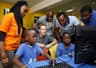 Facebook CEO, Mark Zuckerberg inspecting the activities of some Nigerian kids on the computer on his first visit to Lagos, Nigeria. 