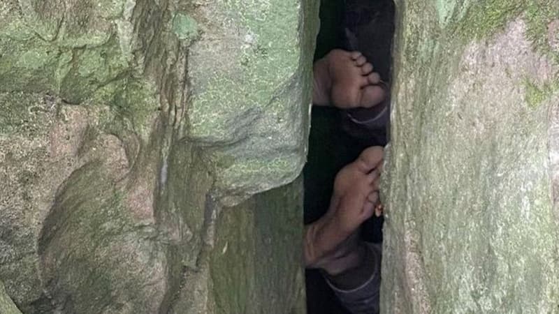 Woman reaching for phone gets stuck upside down in boulders